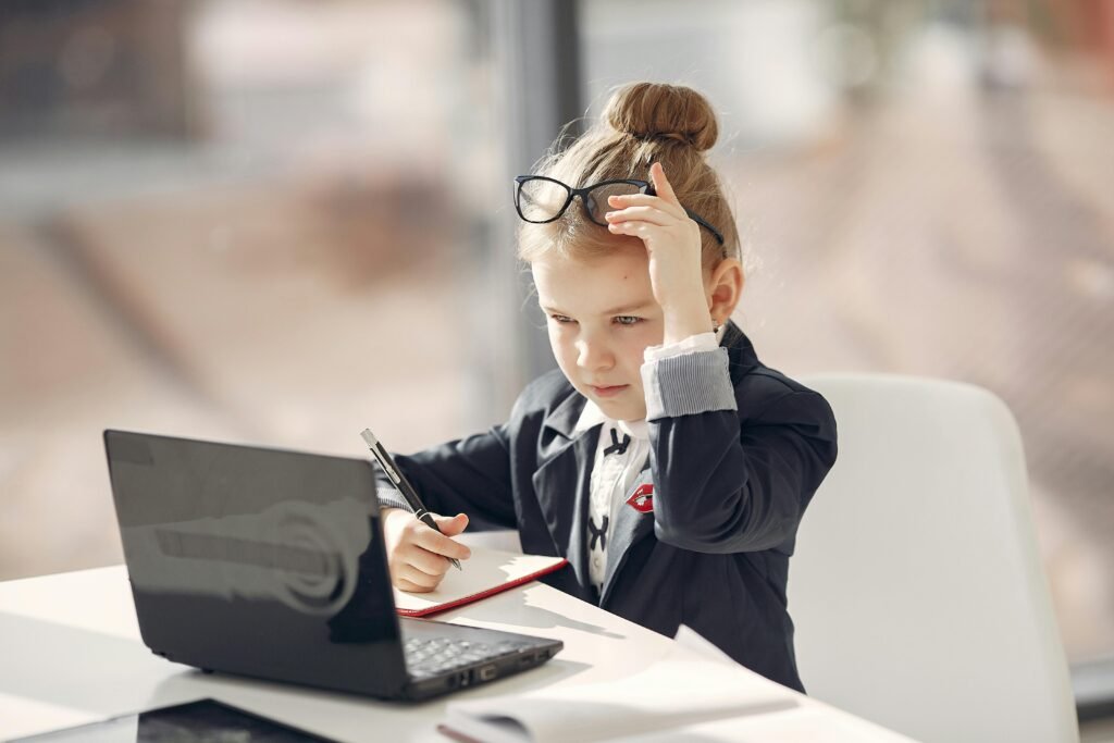 Young girl focused on online homeschool learning with a laptop, representing early education and personalized homeschool programs.