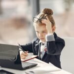 Young girl focused on online homeschool learning with a laptop, representing early education and personalized homeschool programs.